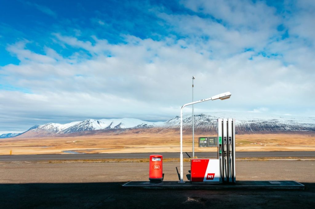 empty gas station near empty road facing snow capped mountain at daytime