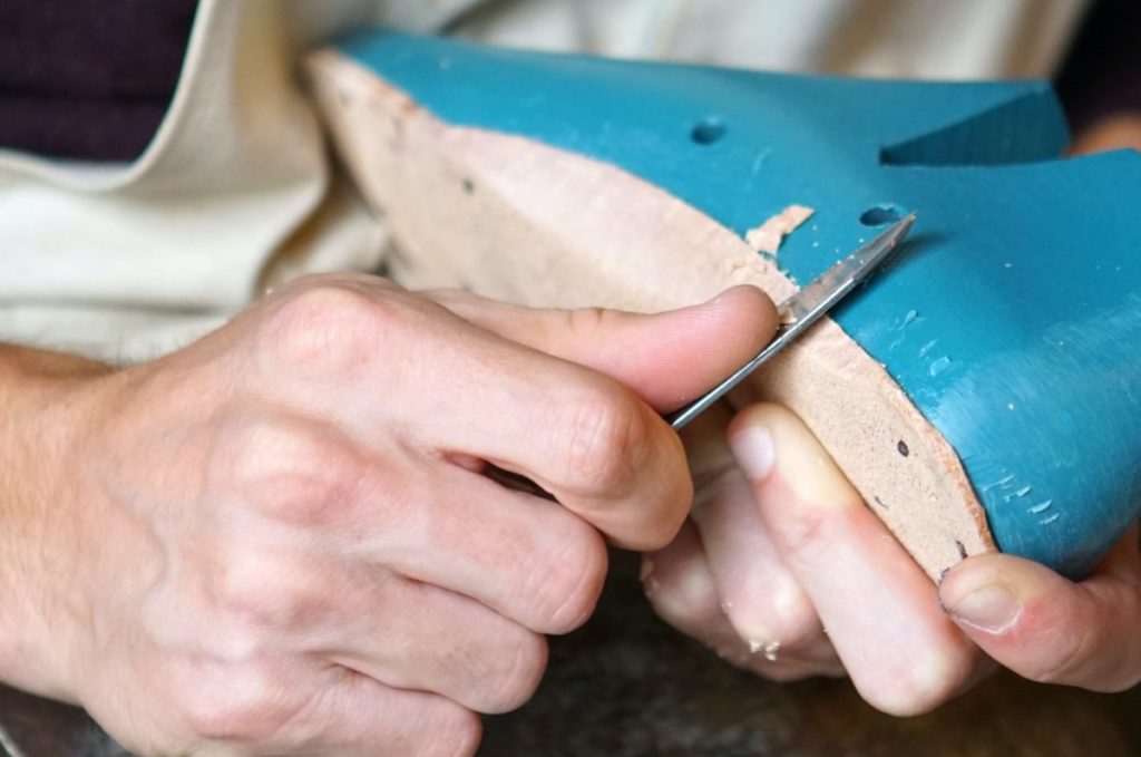 person carving blue footwear