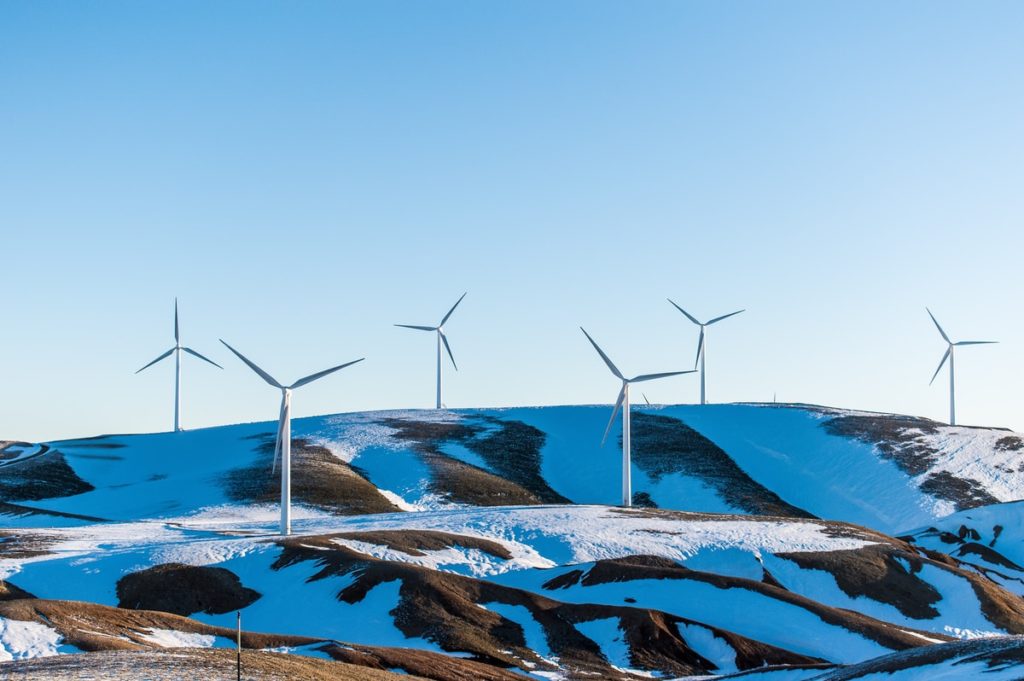 windmills surrounded by snow-covered field during daytime