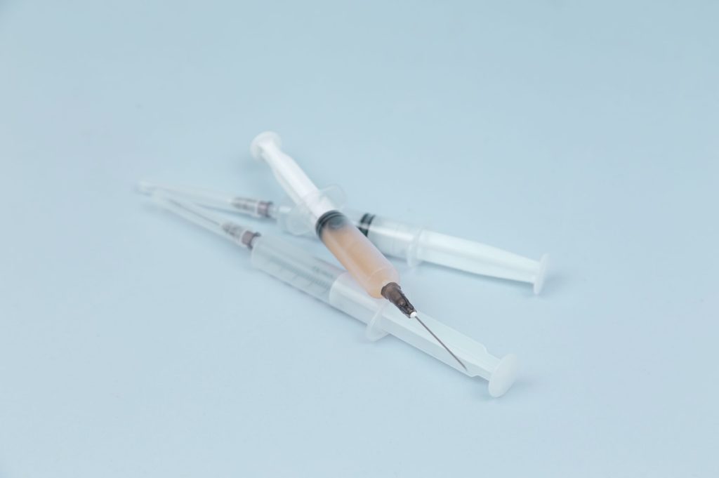 white and clear plastic syringe